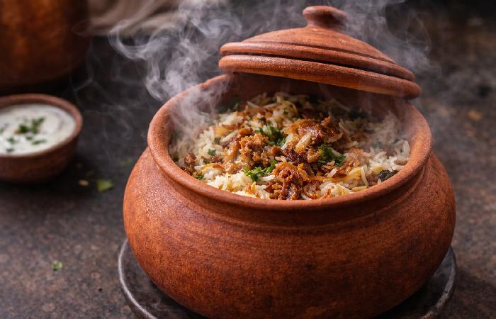 Clay handi with slow-cooked biryani steam escaping — shows cooking use.