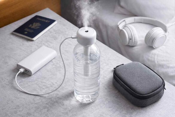 Travel water bottle humidifier on a bedside table with USB power bank